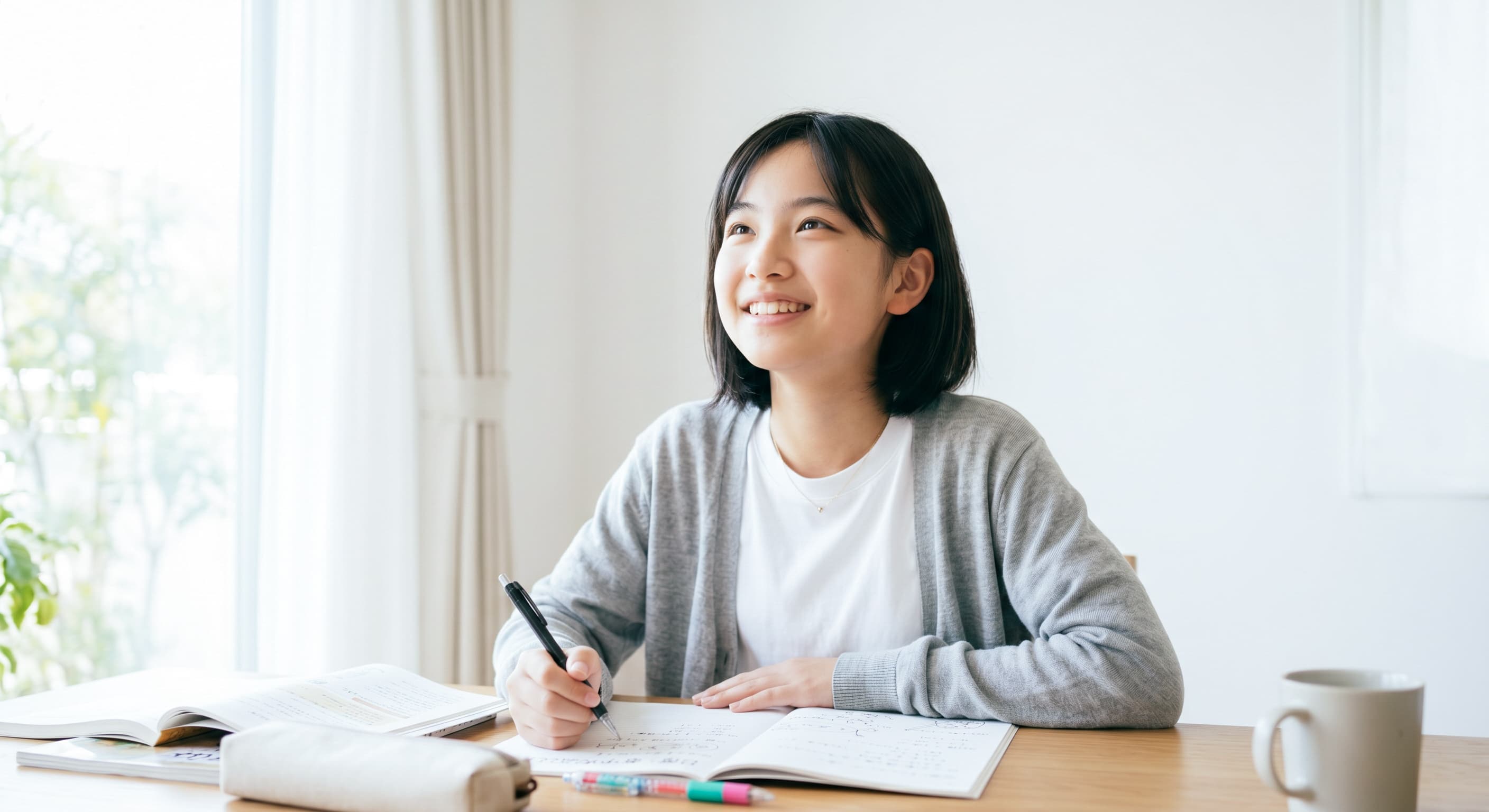 ノートに向かって考える生徒